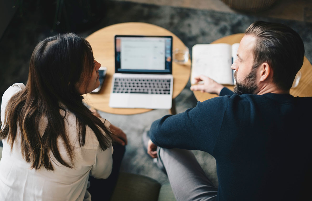 kvinna och man diskuterar framför en laptop